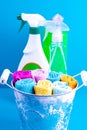 Colorful towels, bucket and cleaning products on a blue background. Detergent for different surfaces in kitchen, bathroom and Royalty Free Stock Photo