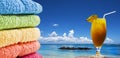 Colorful towels and a fruit cocktail on the beach