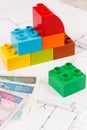 Colorful toy blocks, polish currency money and construction housing plan. Building, buying or renting home concept Royalty Free Stock Photo