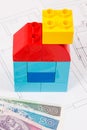 Colorful toy blocks in shape of house, polish currency money and construction housing plan. Buying or renting home concept Royalty Free Stock Photo