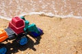 Colorful Toy Excavator on a Sandy Beach