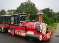 Colorful toy train carrying tourists