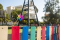 Colorful toy windmill and bright fence on the background of a kidÃ¢â¬â¢s playground. The colors of the rainbow. Royalty Free Stock Photo