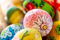 Colorful traditional Easter eggs with floral ornaments, origami decorations and crewel wool, close-up view