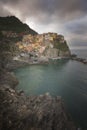 Colorful traditional houses on a rock over Mediterranean sea on dramatic sunset, Manarola, Cinque Terre Royalty Free Stock Photo