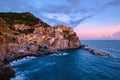 Colorful traditional houses on the rock over Mediterranean sea on dramatic sunset, Manarola, Cinque Terre, Italy Royalty Free Stock Photo