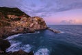 Colorful traditional houses on the rock over Mediterranean sea on dramatic sunset, Manarola, Cinque Terre, Italy Royalty Free Stock Photo