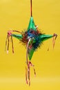 Colorful traditional mexican pinata on yellow background