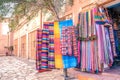 Colorful traditional Moroccan scarves and shawls hanging on a tree for sale. Ouarzazate, Morocco. Royalty Free Stock Photo