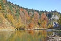 Colorful trees in autumn and Dunajec river at blue sky background. Royalty Free Stock Photo