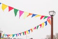 Colorful triangular cloth flags hanging on ropes tied to a lamppost, decoration for festival, carnival, holiday Royalty Free Stock Photo