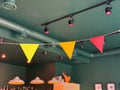 Colorful triangular pennant flags hanging in cafe interior. Celebration, joy, and cheerful design in festive public space. Royalty Free Stock Photo