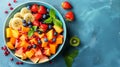Colorful tropical fruit salad with papaya, pomegranate, and banana on green background Royalty Free Stock Photo