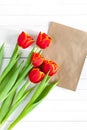 Colorful tulip bouquet and blank greeting card. Top view over white wooden table Royalty Free Stock Photo