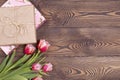 Colorful tulips and gift boxes wrapped in craft paper on a wooden table. Top view with copy space. Flat lay Royalty Free Stock Photo