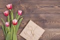 Colorful tulips and gift boxes wrapped in craft paper on a wooden table. Top view with copy space. Flat lay Royalty Free Stock Photo