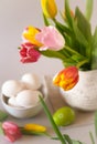 colorful tulips in a vase and a bowl with whole raw white eggs Royalty Free Stock Photo