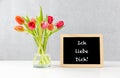 Colorful tulips in a Vase with german text ich liebe dich, in english i love you