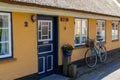 Colorful typical Danish house with a thatched reed roof and a bicycle leaning outside Royalty Free Stock Photo