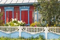 Colorful typical wooden house with ornamental carved windows in Belarus. Summer with flowers