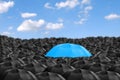 Colorful umbrella in mass of black umbrellas.