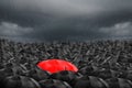 Colorful umbrella in mass of black umbrellas.