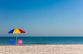 Colorful Umbrella with Pink and Blue Deckchairs on an Empty Beach Royalty Free Stock Photo