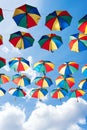 Colorful umbrellas background. Coloruful umbrellas urban street decoration. Hanging Multicoloured umbrellas over blue Royalty Free Stock Photo