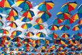 Colorful umbrellas background. Coloruful umbrellas urban street decoration. Hanging Multicoloured umbrellas over blue Royalty Free Stock Photo