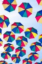Colorful umbrellas background. Coloruful umbrellas urban street decoration. Hanging Multicoloured umbrellas over blue Royalty Free Stock Photo