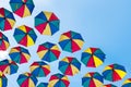 Colorful umbrellas background. Coloruful umbrellas urban street decoration. Hanging Multicoloured umbrellas over blue Royalty Free Stock Photo