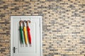 Colorful umbrellas hanging on door in brick wall