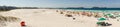 colorful umbrellas and tourists crowd the sand line at Praia do Forte in Cabo Frio, Rio de Janeiro, Brazil Royalty Free Stock Photo