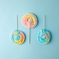 Colorful unicorn rainbow color meringue lollipops candy on pale on blue background. Flat lay. Summer sweet abstract Minimal