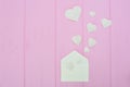 Colorful Valentine Day greeting card envelopes with heart. White hearts pours out of the envelope on pink wooden Royalty Free Stock Photo