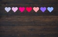 Seven Hearts in Various colors on rustic wood board background