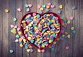 Colorful Valentines mini hearts in red heart box on wood background