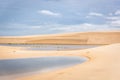 The colorful vast desert landscape of tall, white sand dunes and seasonal rainwater lagoons in a cloudy day at the LenÃÂ§ÃÂ³is Maran