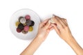 Colorful vegan candies energy balls on a plate with womans hands isolated white background Royalty Free Stock Photo