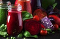 Colorful vegetable juices and smoothies from tomato, carrot, pepper, cabbage, spinach, beetroot in bottles on kitchen table, vegan Royalty Free Stock Photo