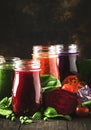 Colorful vegetable juices and smoothies from tomato, carrot, pepper, cabbage, spinach, beetroot in bottles on kitchen table, vegan Royalty Free Stock Photo