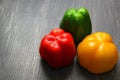 Colorful vegetables and peas, yellow, green and red bell peppers on vintage gray wooden background Royalty Free Stock Photo