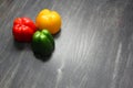 Colorful vegetables and peas, yellow, green and red bell peppers on vintage gray wooden background Royalty Free Stock Photo