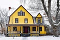 Bright Yellow Victorian House Covered in Snow Royalty Free Stock Photo