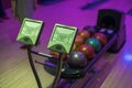 Colorful view of the ball rack and player name introductions in a bowling center.