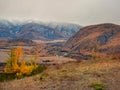 Colorful view to autumn mountain valley with forest and river against mountain range under cloudy sky. Wide mountain valley in Royalty Free Stock Photo