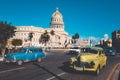 Colorful vintage cars next to the iconic Capitol building in Havana