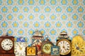 Colorful vintage clocks in front of retro wallpaper