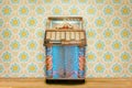 Colorful vintage jukebox in front of retro flower wallpaper