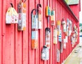 Lobster buoys hanging on the side of a vintage red fishing shack in Massachusetts